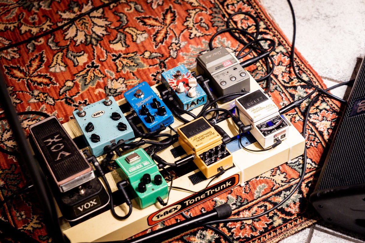 A T-Rex ToneTrunk pedalboard on a patterned rug with a Vox wah, Ibanez Tube Screamer, T-Rex, TC Electronic Flashback delay, JAM, Boss acoustic simulator, Boss chromatic tuner and Ibanez chorus pedals